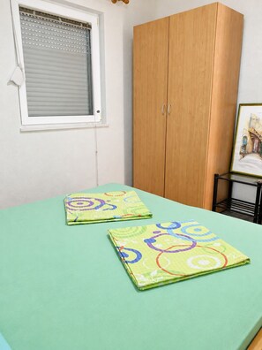 A room with a bed, a window with blinds, a wooden wardrobe, and a framed picture on a small table. - Apartment Vir 1 (Vir)