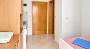 A bedroom with a bed, a bedside table, and a wardrobe. There is a door leading to a bathroom. - Studio Apartment Vir 4 (Vir)