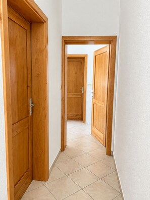 A hallway with wooden doors and tiled flooring. - Apartment Vir 5 (Vir)
