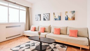 A modern living room with a sofa, a coffee table, and artwork on the wall. - MOT  Rentals + Laprida 1300 - 3 Bd 2 Ba in Recoleta! (Buenos Aires)