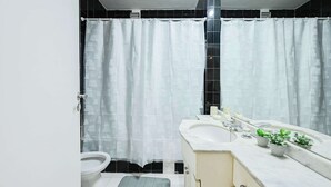 A bathroom with a white shower curtain, a sink with a mirror, and a toilet. - MOT  Rentals + Laprida 1300 - 3 Bd 2 Ba in Recoleta! (Buenos Aires)