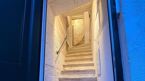 Un escalier menant à l’étage supérieur, avec une rampe et un paillasson au bas.