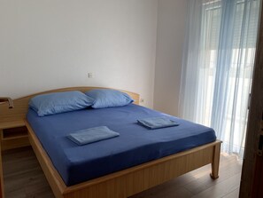 A single bed with a wooden frame and a blue mattress, two pillows, and a folded blanket on the bed. - Apartment Vir 3 in Vir (Vir)