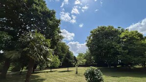 A park with various trees and a clear sky. - French Countryside Retreat With Jacuzzi (Plouasne)