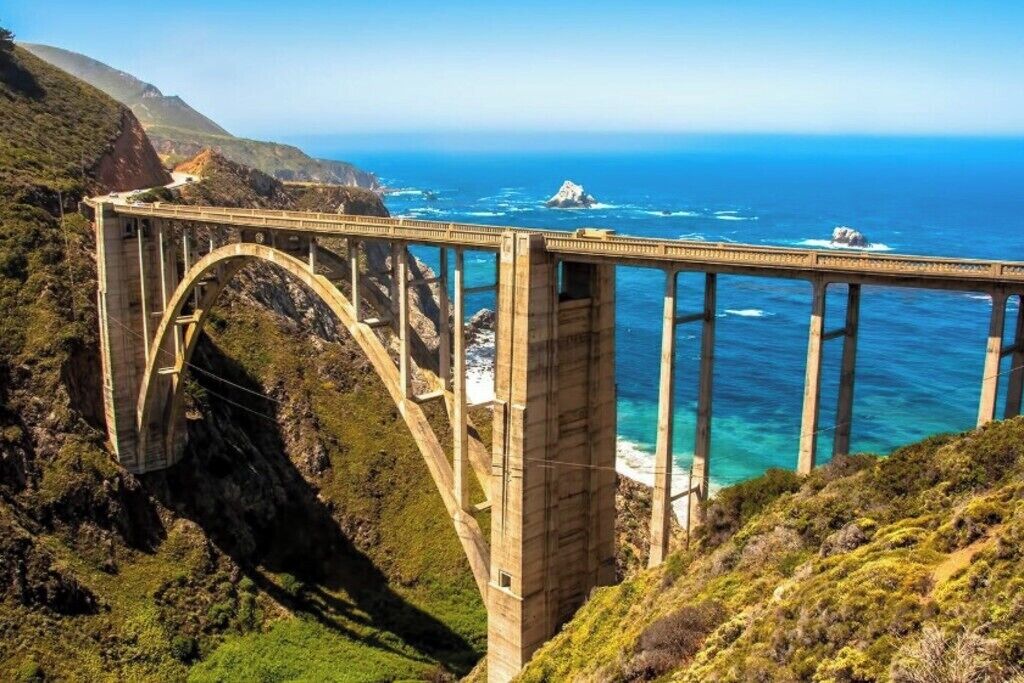 Een grote hangbrug die een diepe kloof overspant, met uitzicht op de kust.