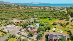 Vista aérea de una zona residencial con casas, una piscina y una montaña al fondo.