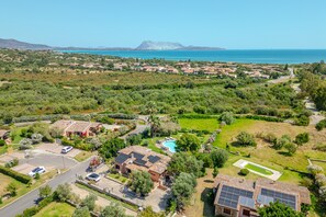Vista aérea de una zona residencial con casas, una piscina y una montaña al fondo.