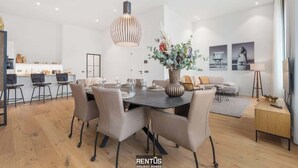 A modern living room with a dining area, a large vase with flowers, and a sofa. - Beach Loft - luxury apartment with sea view in Ostend (Oostende)