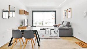 Un espace de vie moderne comprenant un coin repas, un canapé et une grande fenêtre.