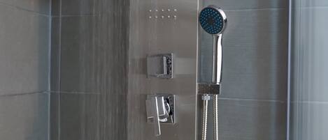 A modern shower with a handheld showerhead and a fixed wall-mounted control panel.