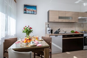 Eine moderne Küche mit Holzschränken, einer Kaffeemaschine und einem Geschirrspüler.