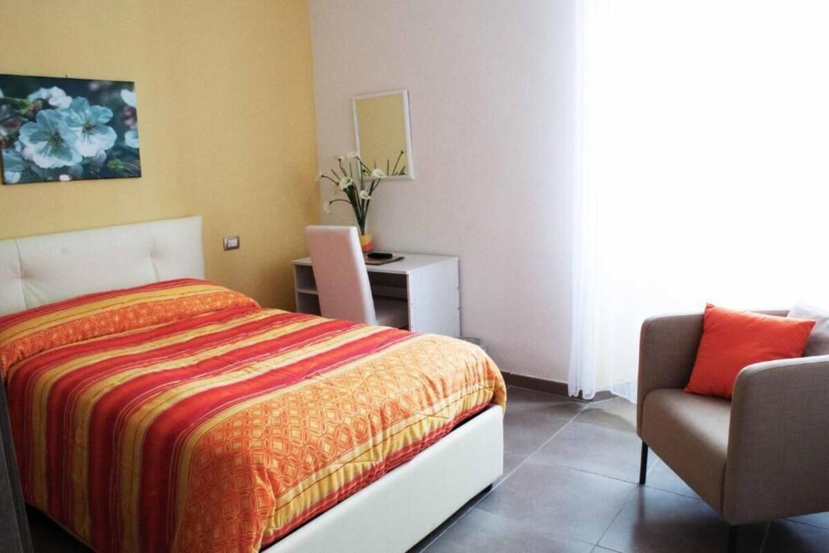 Une chambre d’hôtel avec un lit, un bureau, une chaise et un canapé.