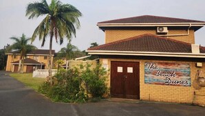 A two-story building with a sign reading "The Beach Dunes." - 5 Beach Dunes (Richards Bay)