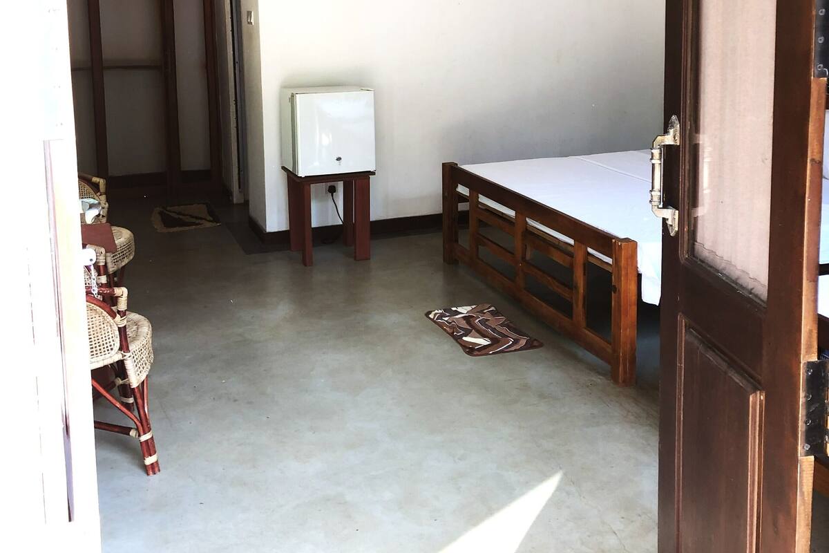 Quarto com cama, aquecedor, ventilador de teto e luminárias de vime.