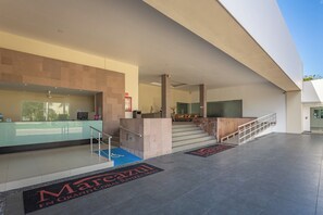 A modern hotel lobby with a reception desk, a staircase, and a blue handicap-accessible mat. - New Mareazul Resort swim up short walk to beach 2 bdrm 2bath Casa Mistica (Playa del Carmen)