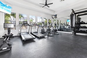 A gym with treadmills, elliptical machines, and a punching bag. - Landing Furnished Apartments - Far West Side (San Antonio)