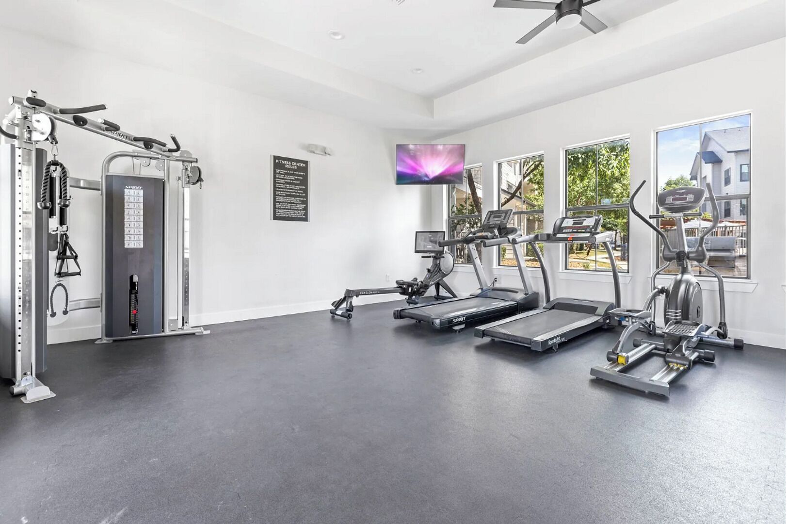 Un centre de remise en forme équipé de tapis de course, de vélos elliptiques et d'appareils de musculation.
