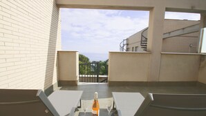 A balcony with two chairs, a bottle of wine, and two glasses on a mat. - Apartment Panoramic 25 by Parc Mont-roig (Miami Playa)