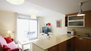 A compact kitchen with a dining area, a TV, and a microwave. - Apartment Panoramic 26 by Parc Mont-roig (Miami Playa)