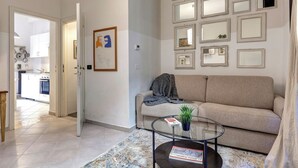 En stue med sofa, sofabord og en væg pyntet med flere spejle.