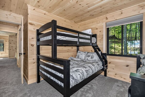 A bunk bed with a view of the outdoors through a window.