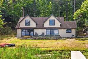 A two-story house with a front porch, large windows, and a deck area. - An Adventure Awaits -  Stepaway Vacation Rentals (St.Germain)