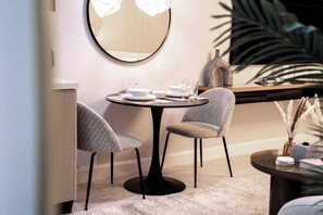 A dining area with a round table, two chairs, and a mirror on the wall. - Free housekeeping visits during your stay - StayShort - Stunning Studio Unit in Business Bay that Sleeps 2! (Business Bay)
