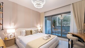 Quarto de hotel moderno com uma cama grande, abajures, porta de vidro que dá para uma varanda e vista para o exterior.