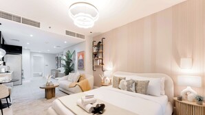 Quarto moderno com uma cama grande, mesas de cabeceira, prateleira embutida e vista para a sala de estar.