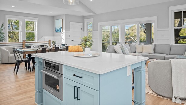 A spacious kitchen with a central island, built-in appliances, and large windows offering views of the outdoors. - Private Pool + Hot Tub | New 5BR w/ Golf Cart – Steps to Beach (Emerald Isle)