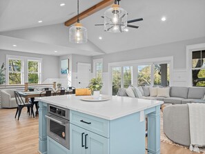 A spacious kitchen with a central island, built-in appliances, and large windows offering views of the outdoors. - Private Pool + Hot Tub | New 5BR w/ Golf Cart – Steps to Beach (Emerald Isle)