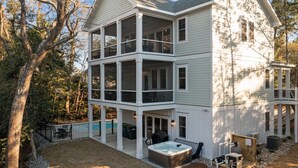 A two-story house with a covered patio, a hot tub, and a swimming pool. - Private Pool + Hot Tub | New 5BR w/ Golf Cart – Steps to Beach (Emerald Isle)