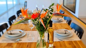 A long dining table with chairs, a vase with flowers, wine glasses, and plates set for a meal. - Cachito de Cielo (La Victoria de Acentejo)