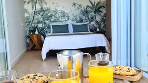 A bedroom with a bed, a nightstand, a window, and a breakfast tray with cookies and orange juice. - Cachito de Cielo (La Victoria de Acentejo)