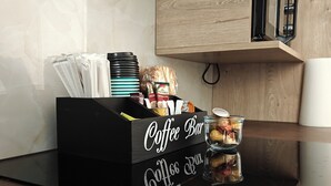 A kitchen with a coffee bar, a wooden cabinet, and a black countertop. - Marousi Serene Suite (Marousi)