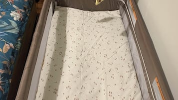 A hospital bed with a white sheet and a star-shaped pillow.