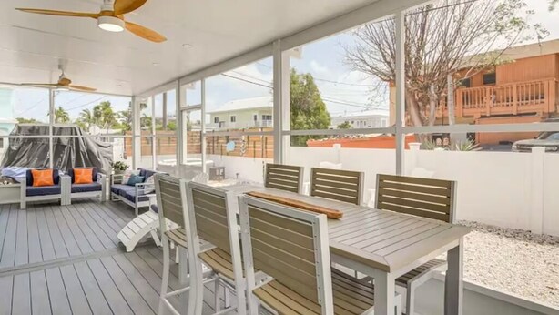 An outdoor patio with a table and chairs, ceiling fans, and a view of the neighborhood. - Escape & Relax in the heart of Key Largo, Florida (Key Largo)