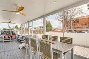 An outdoor patio with a table and chairs, ceiling fans, and a view of the neighborhood. - Escape & Relax in the heart of Key Largo, Florida (Key Largo)