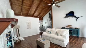 A spacious living room with a white sofa, a wooden ceiling, and a teal sideboard. - Escape & Relax in the heart of Key Largo, Florida (Key Largo)