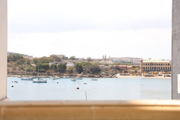 A harbor with boats, a yacht yard, and buildings in the background.
