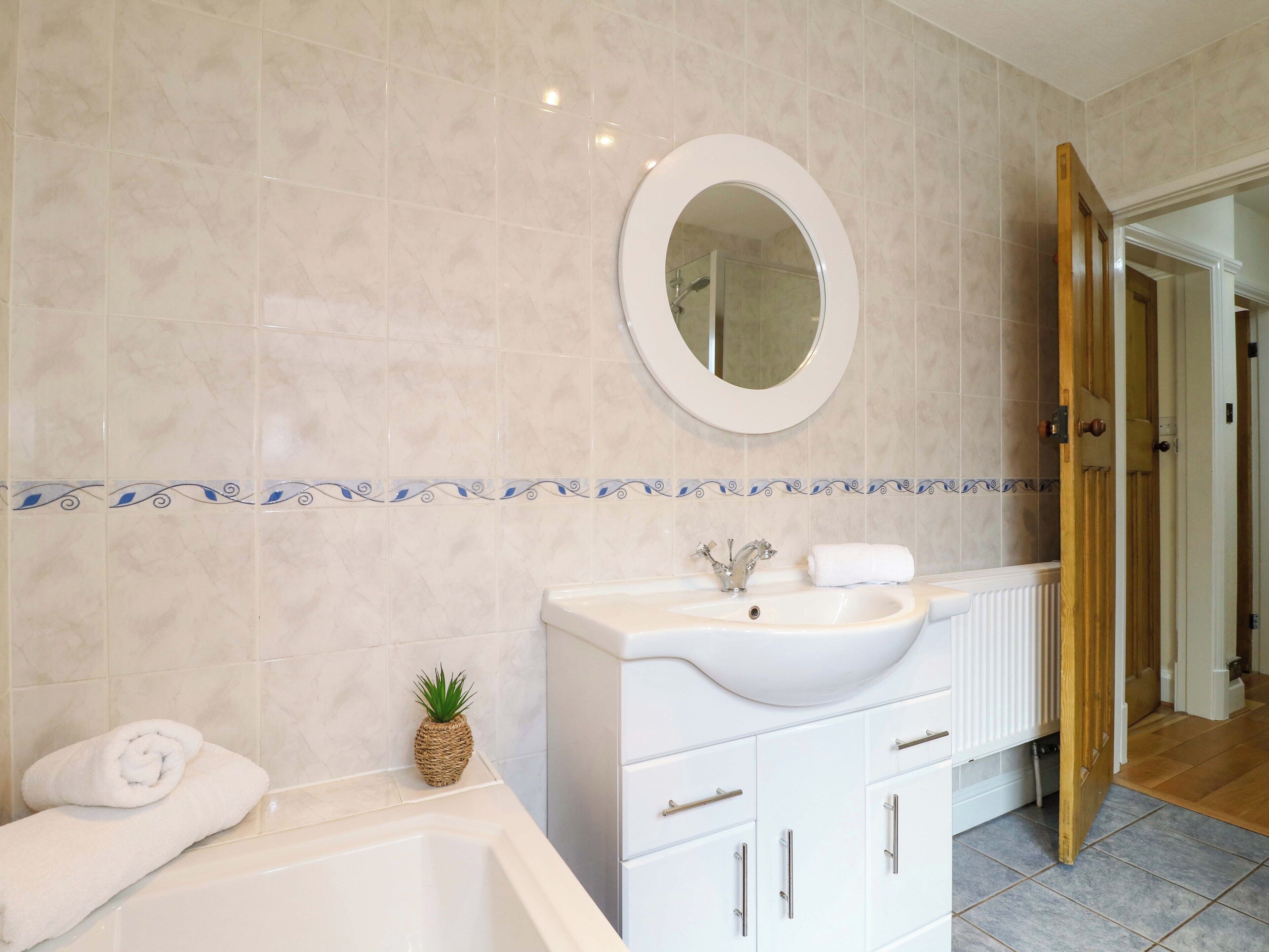 Un bagno con una vasca, un lavandino e uno specchio.