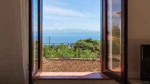 A room with a sliding glass door leading to a balcony with a view of the sea and mountains. - Zingaro Anima Maris, between Scopello and Zingaro (CASTELLAMMARE DEL GOLFO)