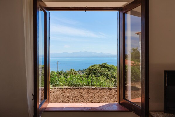 A room with a sliding glass door leading to a balcony with a view of the sea and mountains. - Zingaro Anima Maris, between Scopello and Zingaro (CASTELLAMMARE DEL GOLFO)