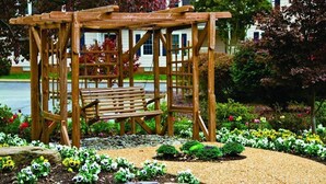 A wooden pergola with a bench in a garden setting. - Cozy 1 bedroom condo in Williamsburg, Virginia! (Williamsburg)