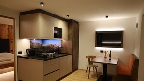 Eine moderne Küche mit Mikrowelle, Herd und Essbereich mit Tisch und Stühlen.