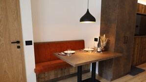 Una cocina moderna con un banco de madera, una mesa de comedor y una lámpara colgante.