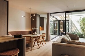A modern interior with a dining area, sofa, and large windows. - Nosso Logies · 2 min to Beach · Terrace · Knokke (Knokke-Heist)