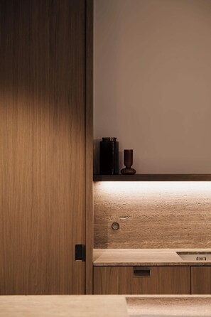 Ein Holzschrank mit eingebautem Regal, einer kleinen Dose und einer Tasse.