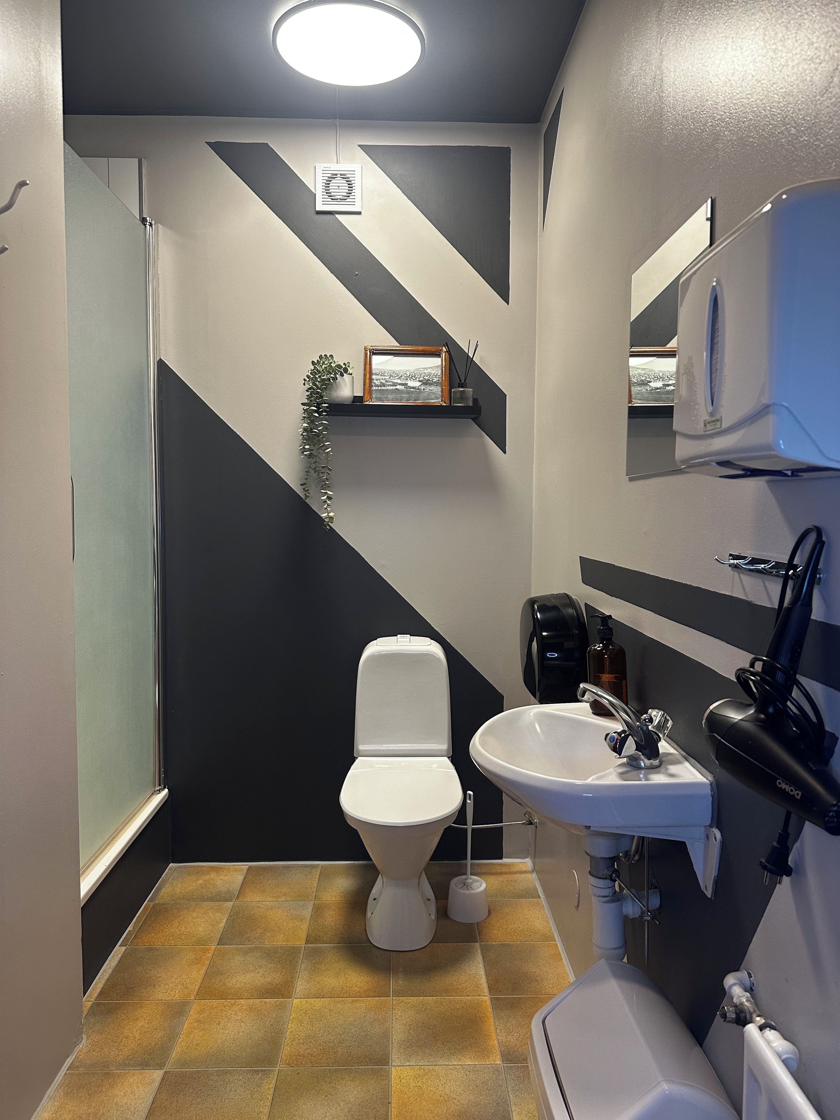 Un baño con inodoro, lavamanos y espejo.