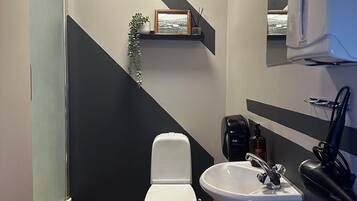Un baño con inodoro, lavamanos y espejo.